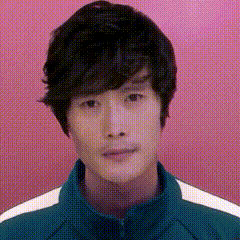 a man with short black hair is wearing a green and white jacket .