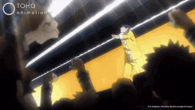 a man in a yellow suit is standing in front of a crowd with toho animation written on the bottom of the screen