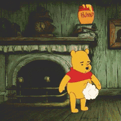 winnie the pooh is standing in front of a fireplace with a jar of honey on top