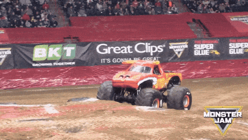 a monster jam truck is driving down a dirt road