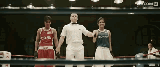 three female boxers are standing in a boxing ring and one of them is wearing a jersey that says monnp