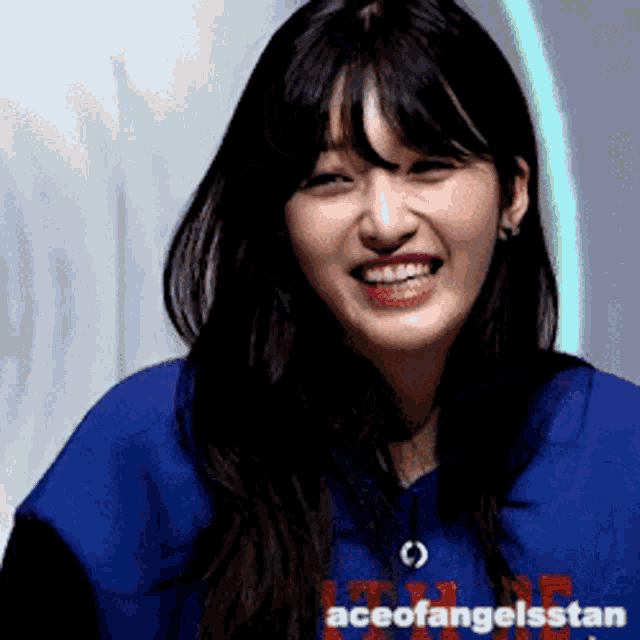 a woman wearing a blue shirt with aceofangelsstan written on the bottom