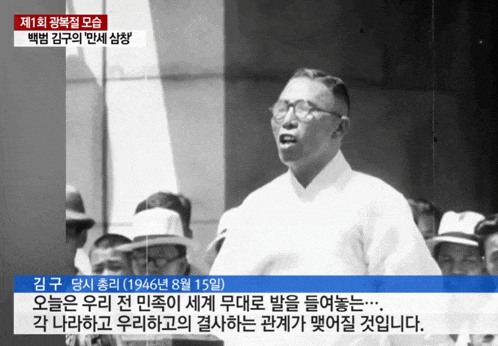 a black and white photo of a man with glasses speaking in front of a crowd