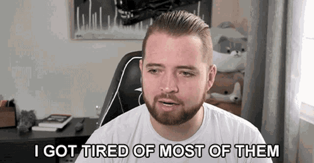 a man with a beard is sitting in a chair and says i got tired of most of them