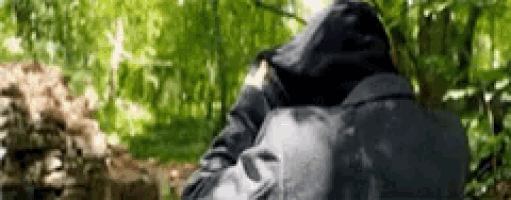 a person with a backpack standing in the woods .