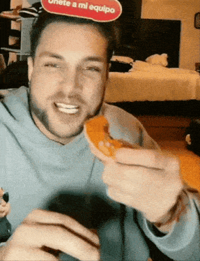a man is eating a donut with a sign that says " unete a mi equipo "