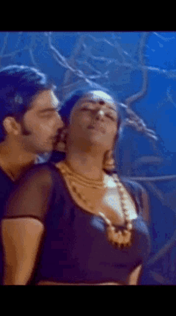 a man is kissing a woman on the neck