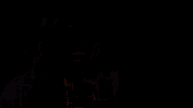 a man and a woman are standing next to each other in a dark room with a red light coming from their hands .