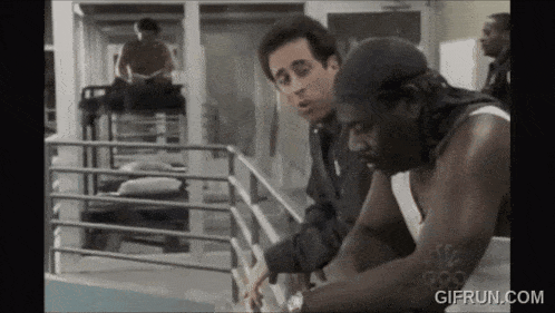 a man is talking to another man with a gif run.com watermark on the bottom