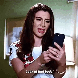 a woman is crying while looking at her phone and says `` look at that body '' .