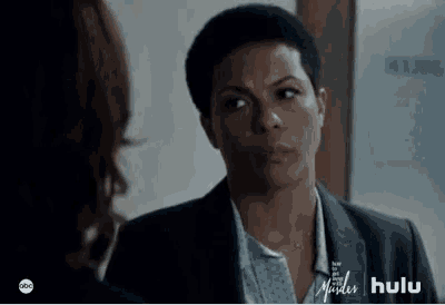 a woman in a suit is looking at another woman in a room .