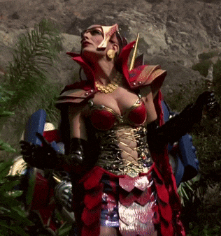 a woman in a red and gold costume stands in a forest