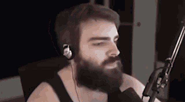 a man with a beard wearing headphones and a microphone .