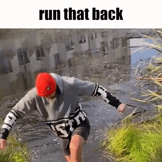 a man is running through a puddle of water with the words `` run that back '' above him .