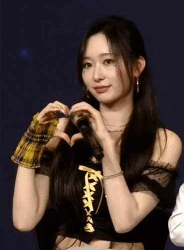 a young woman making a heart shape with her hands