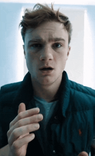 a young man wearing a blue vest with a red polo logo on it