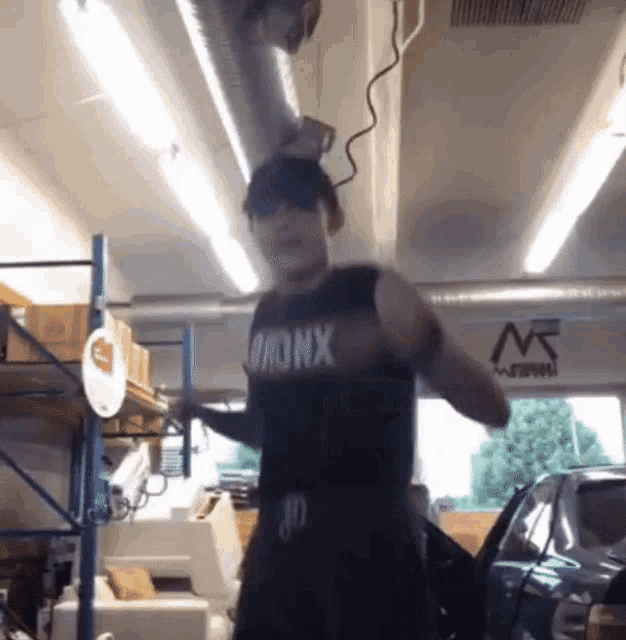 a man in a bronx tank top is standing in a garage