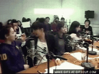 a group of people are sitting at a table with microphones and a make gifs at gifsoup.com watermark