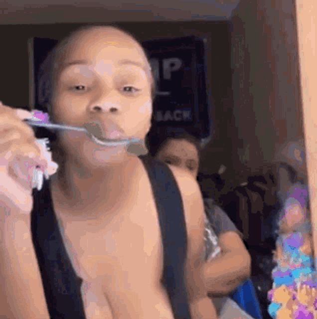 a woman is brushing her teeth with a toothbrush and a green toothpaste .