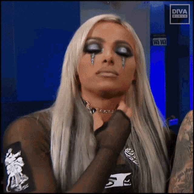 a woman with tears running down her face is wearing a diva branded shirt