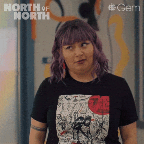a woman with purple hair is wearing a black shirt that says north of north on the bottom