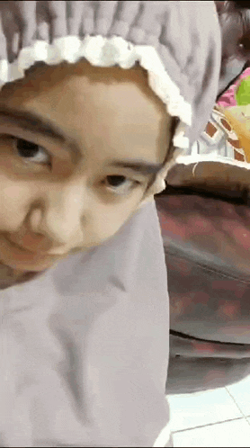 a little girl wearing a hijab and a hat looks at the camera .