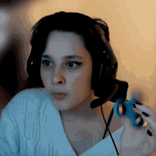a woman is wearing headphones and holding a blue toy