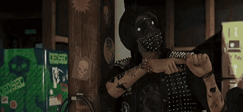 a man wearing a mask and a hat is standing in a room with stickers on the wall .