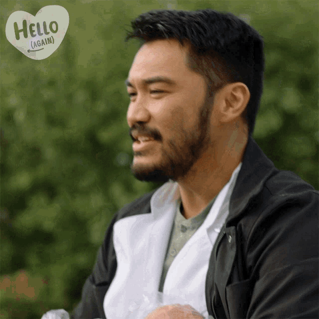 a man with a beard has a heart that says hello again on it
