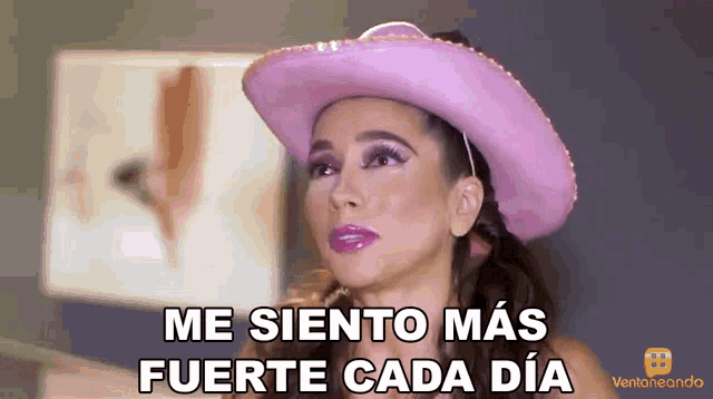 a woman wearing a pink cowboy hat says " me siento mas fuerte cada dia "