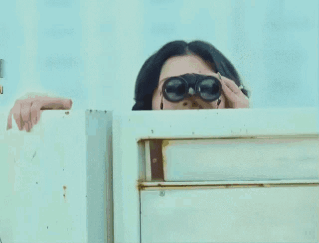 a woman looking through binoculars with the letter u on the bottom