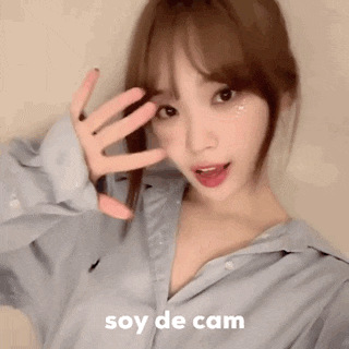 a blurry picture of a woman making a funny face with the words soy de cam written on the bottom .