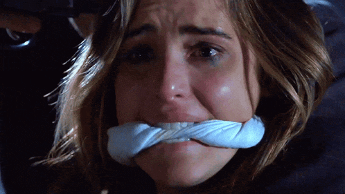a woman with a bandage on her mouth is crying