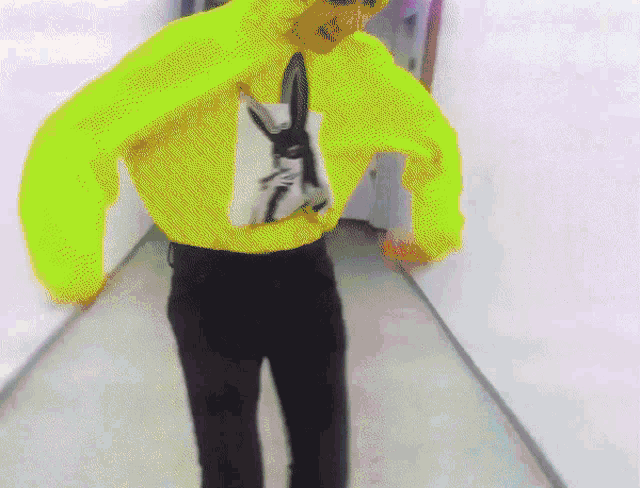 a person wearing a neon yellow hoodie with a picture of a bunny on it