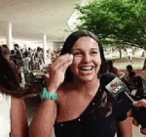 a woman is laughing while being interviewed by a reporter .