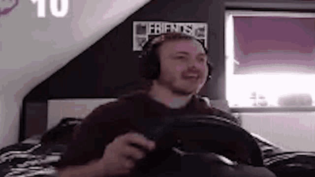 a man wearing headphones is playing a video game on a bed .