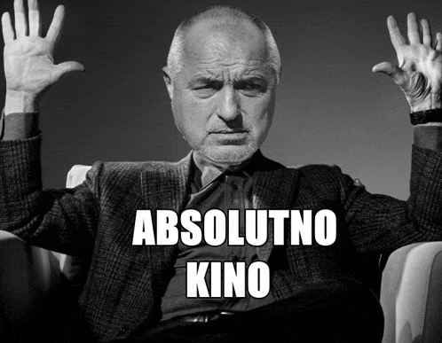 a man in a suit is sitting in a chair with his hands in the air and the words absolutno kino written below him