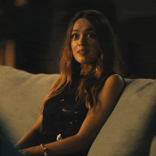 a woman is sitting on a couch with her back to the camera