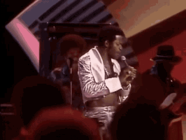 a man is singing into a microphone while standing on a stage .