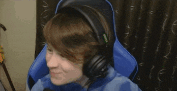 a young boy wearing headphones is sitting in a blue chair in front of a computer .