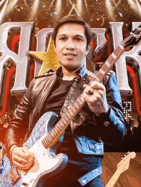 a man in a leather jacket holds a guitar in front of a sign that says rock