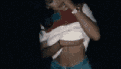 a blurry picture of a woman taking off her shirt in the dark .