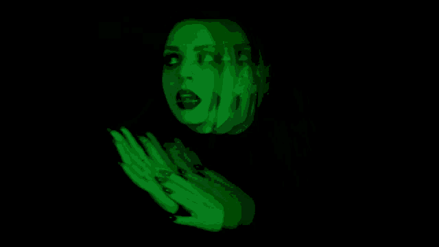 a woman 's face is projected on a black background with green lights