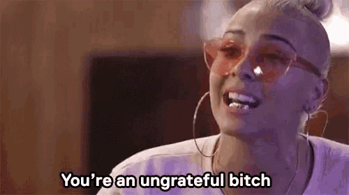 a woman wearing pink sunglasses is smoking a cigarette and says `` you 're an ungrateful bitch '' .