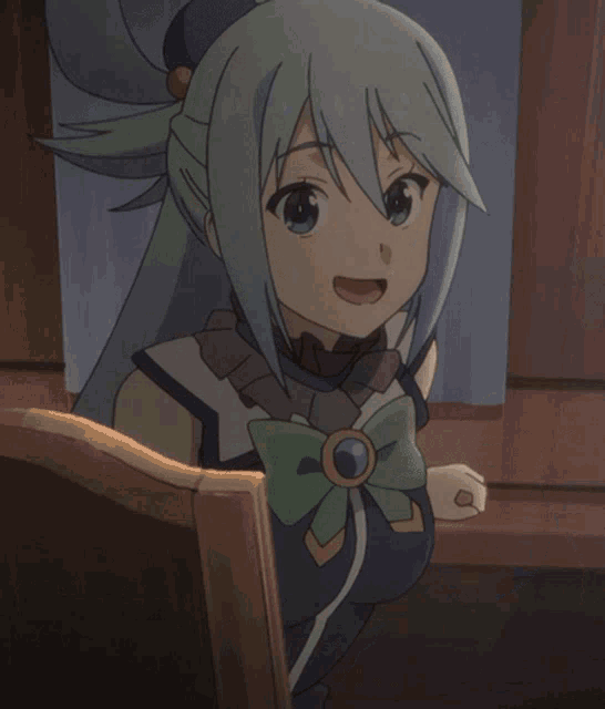 a girl with blue hair and a green bow is sitting at a table