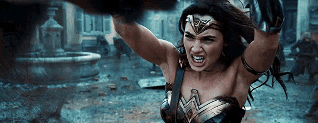 a woman in a wonder woman costume is holding her arms in the air
