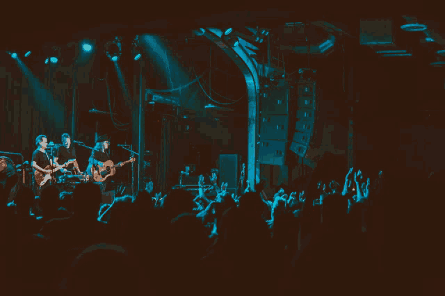 a group of people playing guitars on a stage