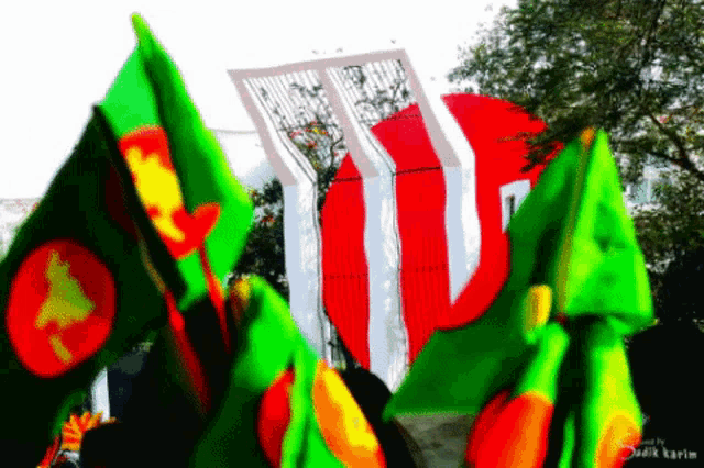 a bunch of flags are flying in front of a statue