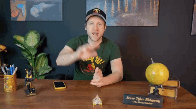 a man sitting at a desk with a name plate that says " jesse tyler ridgway "