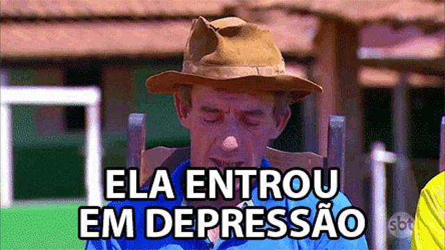 a man wearing a cowboy hat is sitting in a chair with the words " ela entrou em depressão " written above him